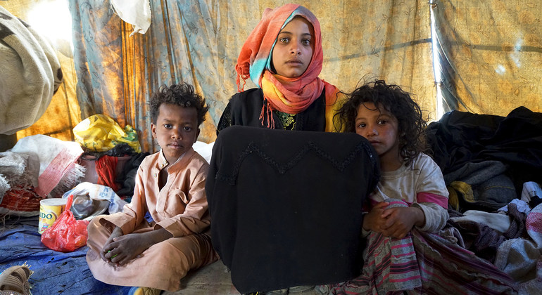 一名15岁的女孩和她的两个兄弟坐在也门一境内流离失所者定居点的帐篷里，和他们住在一起的还有其他五个兄弟姐妹。