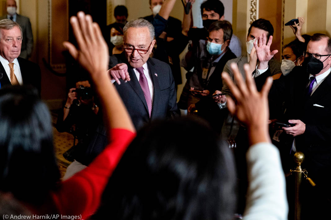 Politician calling on reporters who are raising hands to ask questions (© Anrew Harnik/AP)