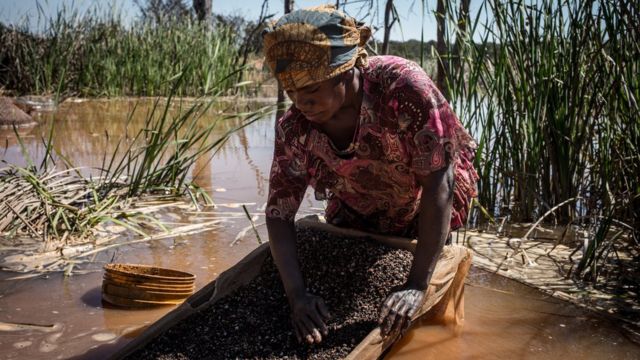 A woman separates cobalt from mud and rocks near a mine between Lubumbashi and Kolwezi in the DRC.