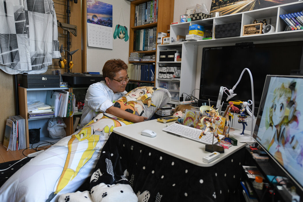 渡边康明抱着动画片角色立花响的枕头。