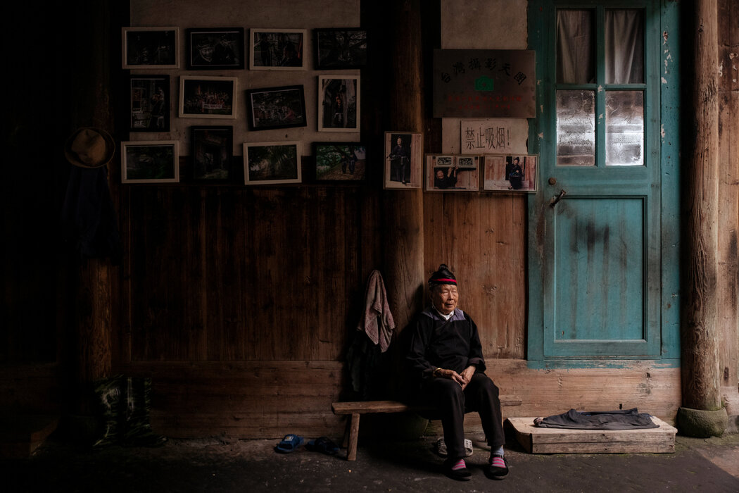 钟莲娇（音）现年90岁，是畲族人，她靠让人摆拍赚钱。她家的墙壁上贴着一些摆拍的照片。